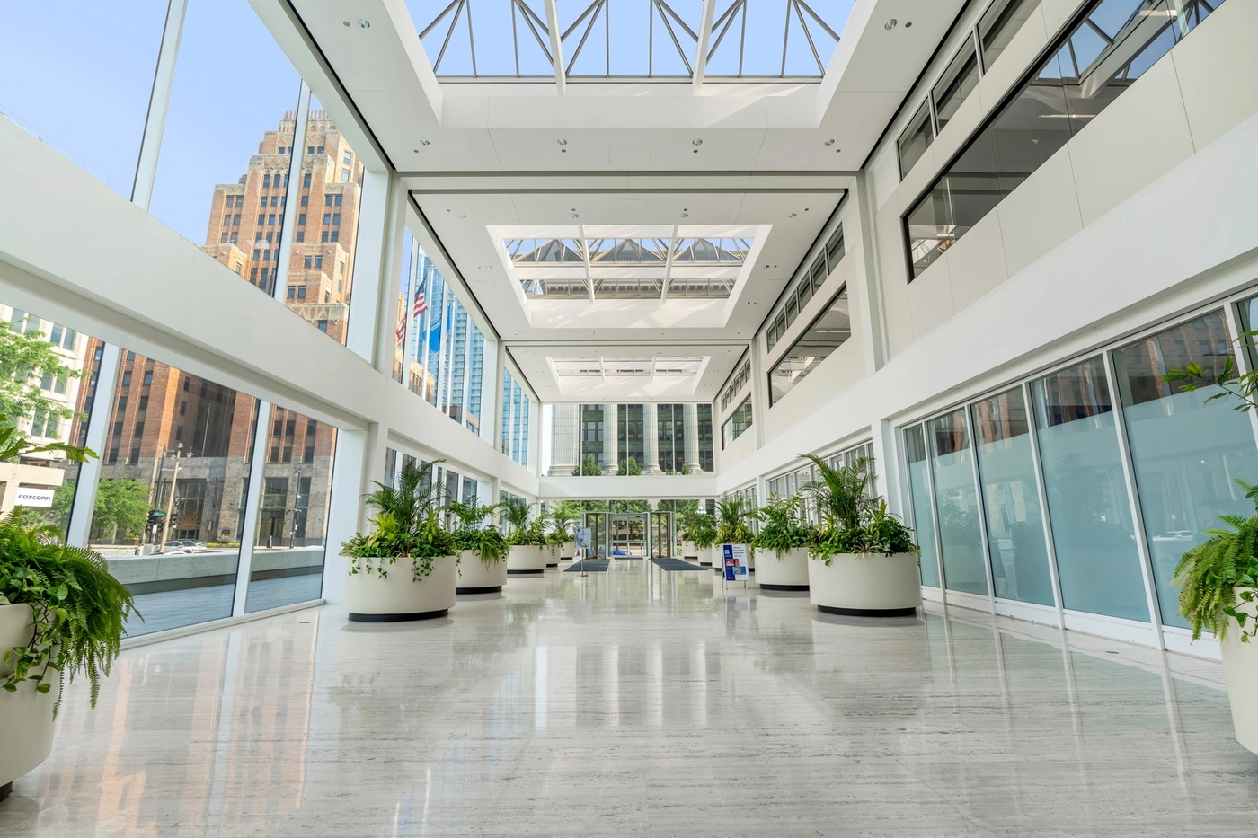 U.S Bank Center building features multi-story skylit atrium adorned with lush greenery and Italian travertine